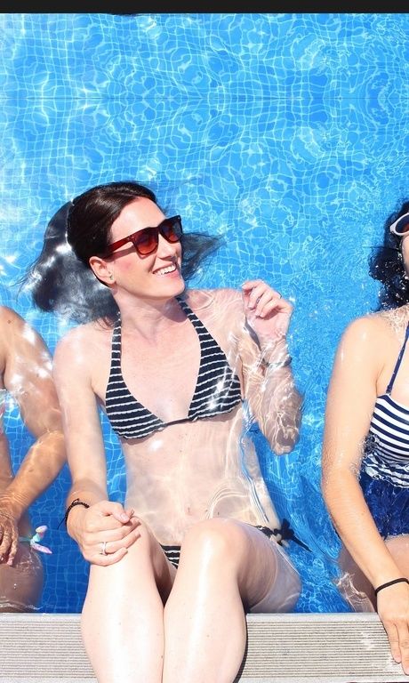 Drei Frauen genießen die Zeit gemeinsam bei viel Sonne im Pool.
