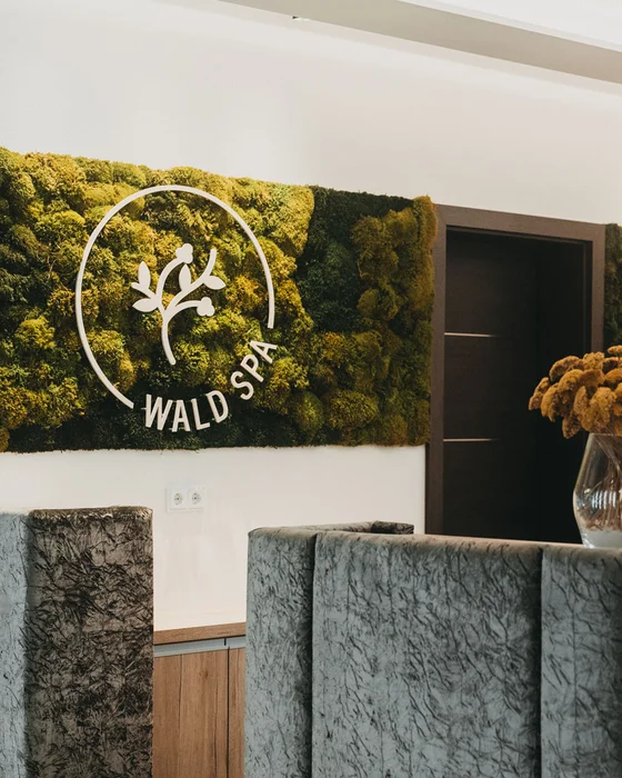 Eibl Brunner: dein Hotel in Frauenau Rezeption im Wald Spa mit Mooswand und Blumenstrauß in Vase
