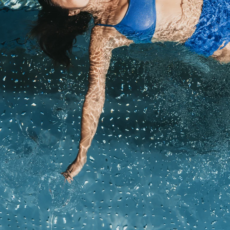 Eibl Brunner: dein Hotel in Frauenau Frau im blauen Bikini schwimmt im klaren Wasser